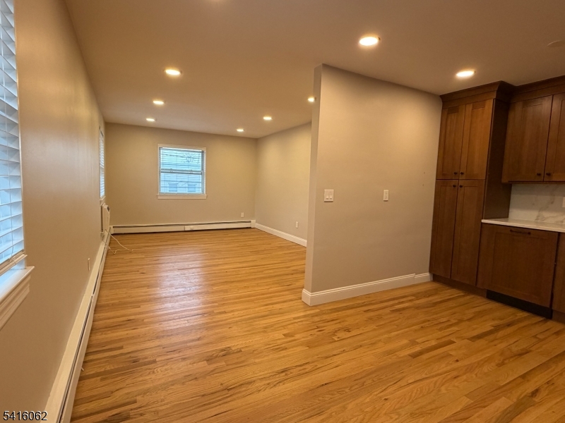 93 Centre Street Nutley, NJ 07110 - Photo 3 of 8 an empty room with wooden floor and windows