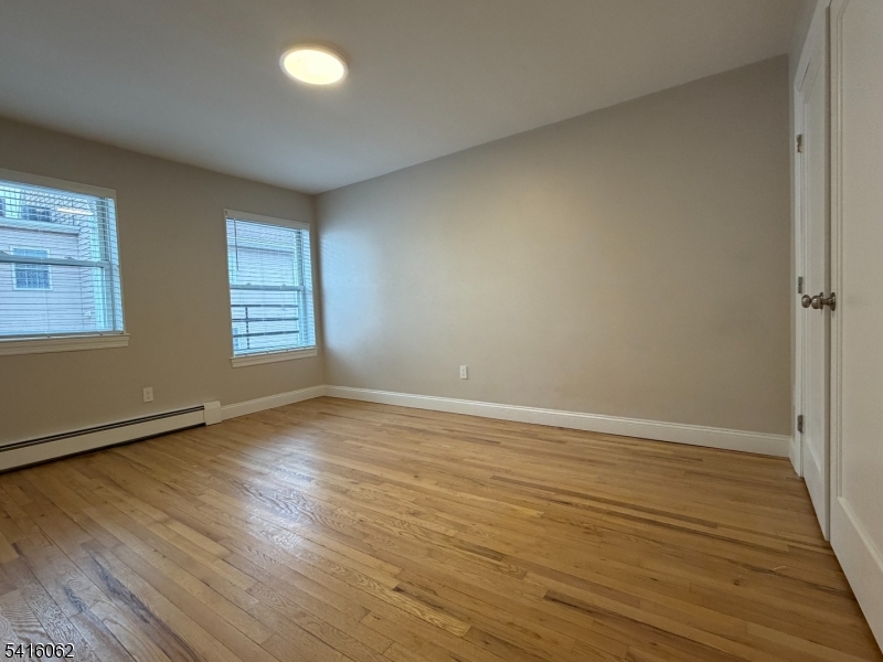93 Centre Street Nutley, NJ 07110 - Photo 5 of 8 an empty room with wooden floor and windows