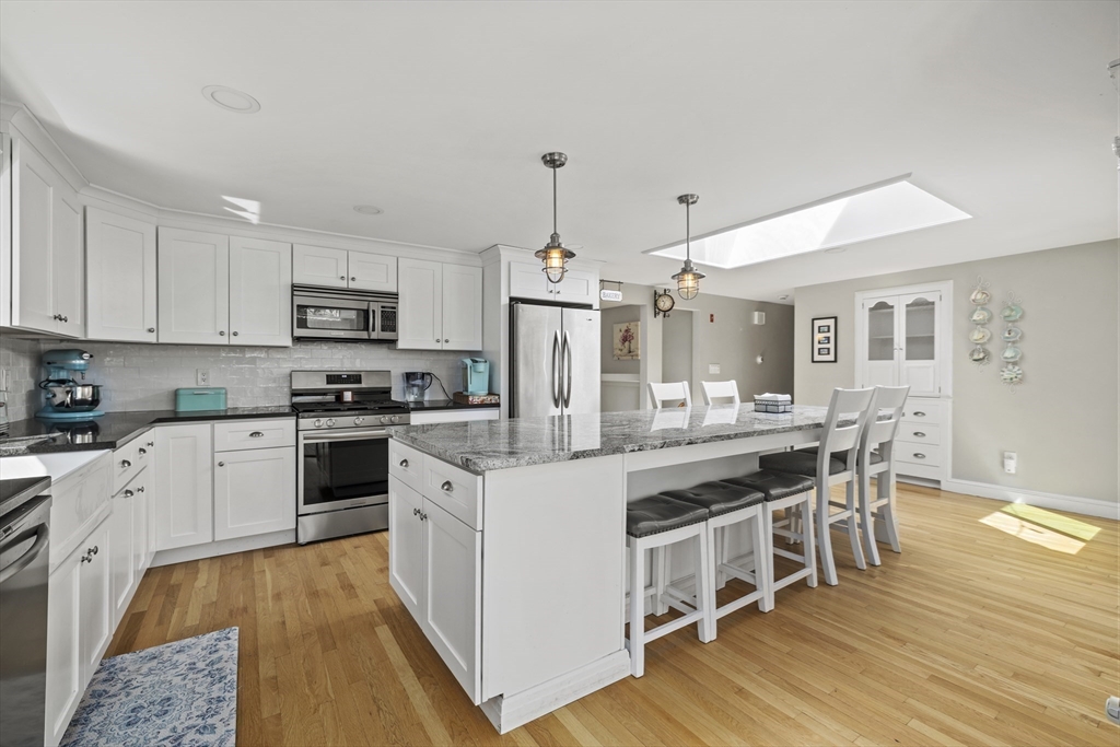 21 Reading Terrace Reading, MA 01867 - Photo 3 of 42 a kitchen with stainless steel appliances a white stove top oven a sink dishwasher and a refrigerator