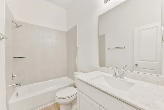 a bathroom with a granite countertop sink a toilet and a bathtub