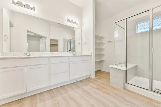 a spacious bathroom with a double vanity sink and a mirror