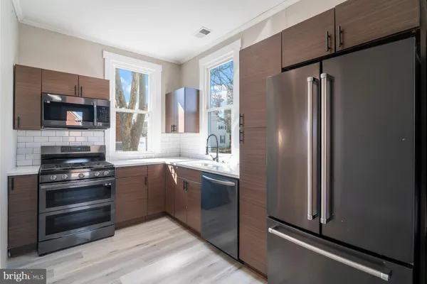 a kitchen with stainless steel appliances granite countertop a refrigerator and a stove