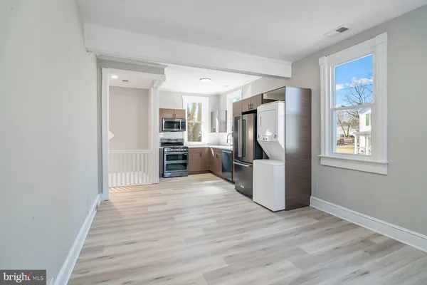 a view of a kitchen with fridge and wooden floor