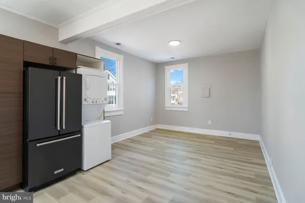 a view of a kitchen with refrigerator and wooden floor