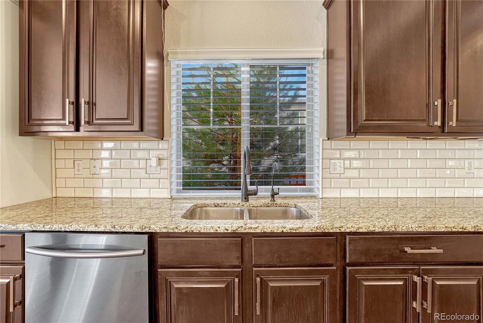 3359 Starry Night Loop Castle Rock, CO 80109 - Photo 11 of 47 a kitchen with granite countertop a sink and a wooden cabinets