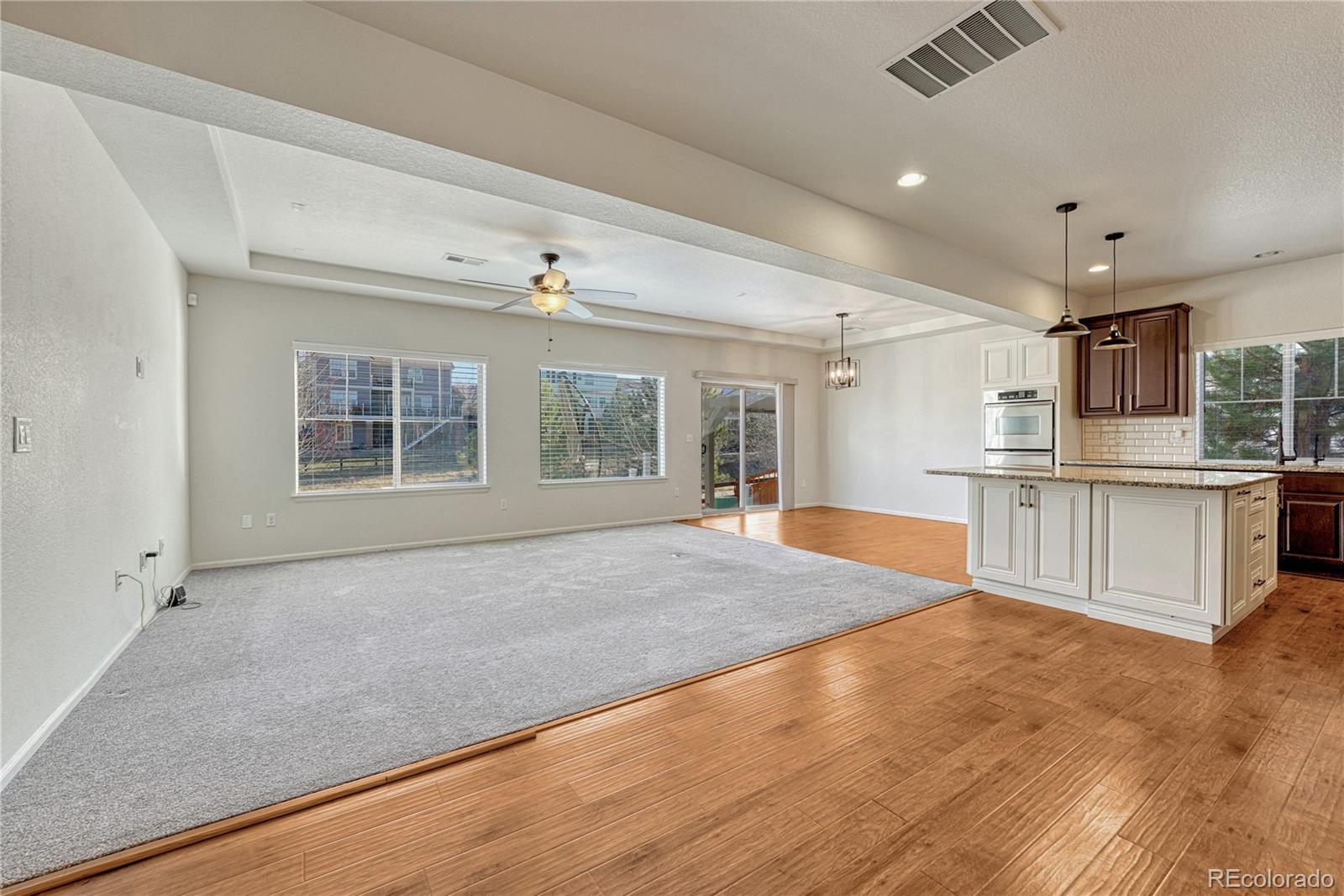 3359 Starry Night Loop Castle Rock, CO 80109 - Photo 16 of 47 a large room with kitchen area wooden floor and front door