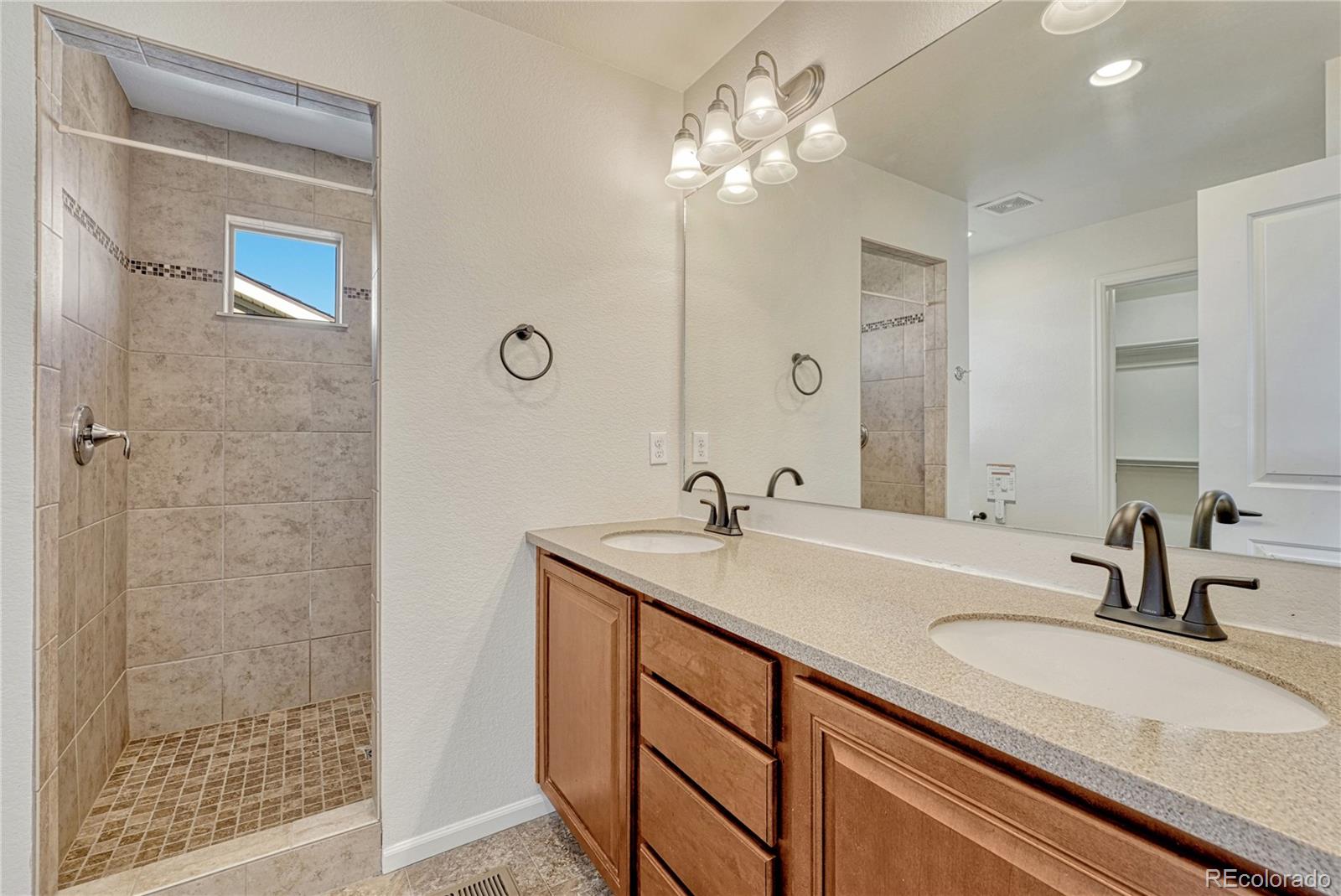 3359 Starry Night Loop Castle Rock, CO 80109 - Photo 24 of 47 a bathroom with a sink double vanity and shower
