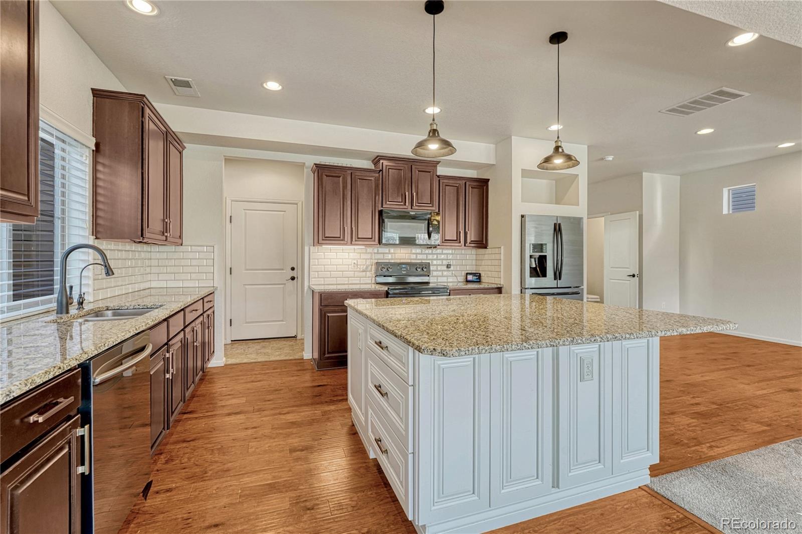 3359 Starry Night Loop Castle Rock, CO 80109 - Photo 8 of 47 a kitchen with stainless steel appliances granite countertop a sink stove and refrigerator