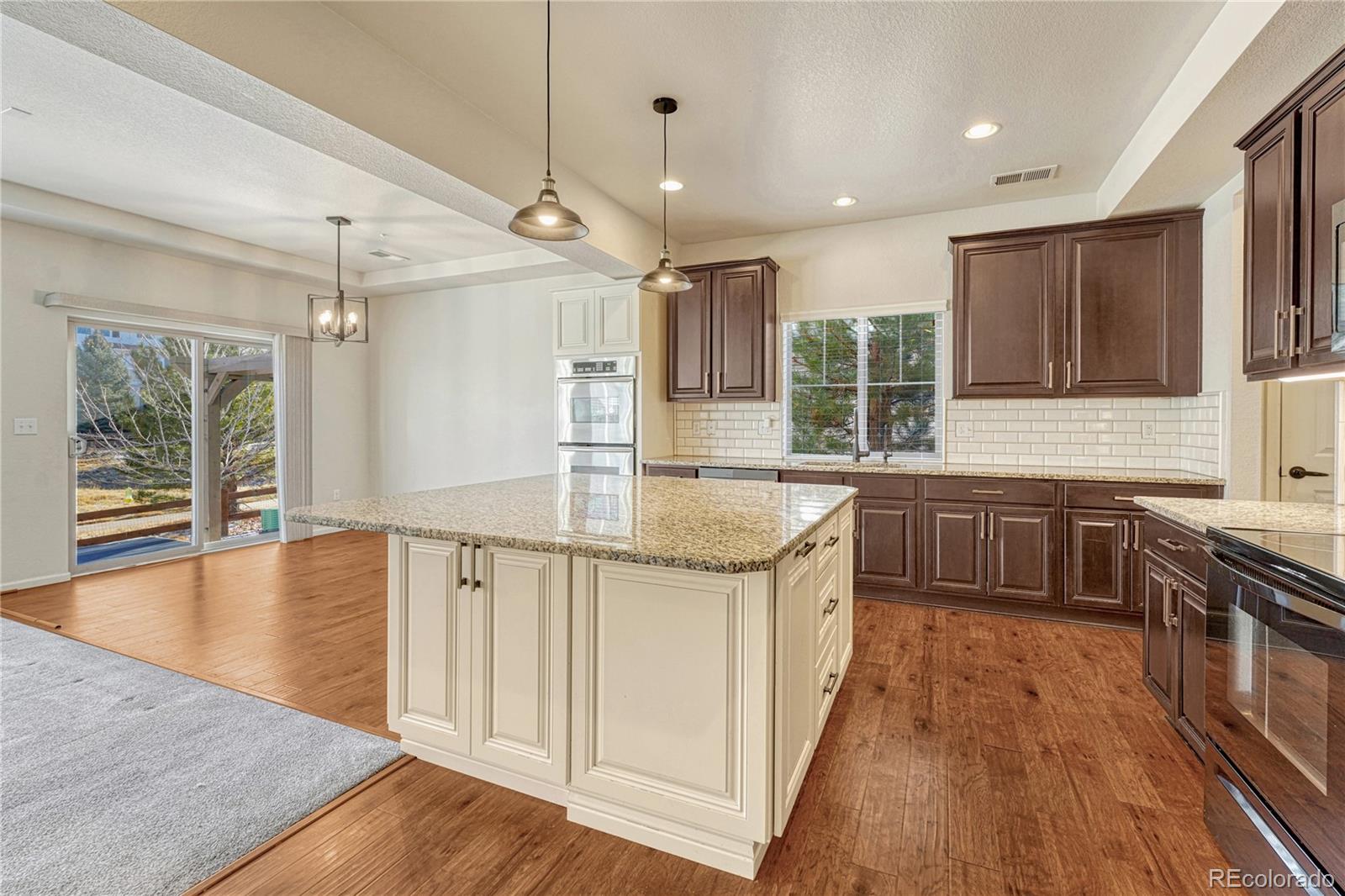 3359 Starry Night Loop Castle Rock, CO 80109 - Photo 10 of 47 a kitchen with stainless steel appliances granite countertop a sink a stove and a wooden floors