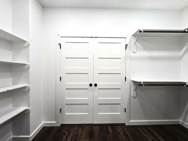 a view of walk in closet with wooden floor