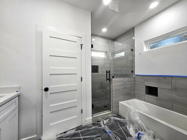 a bathroom with a double vanity sink a toilet and shower