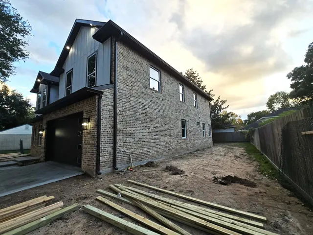 a front view of a house with a tree