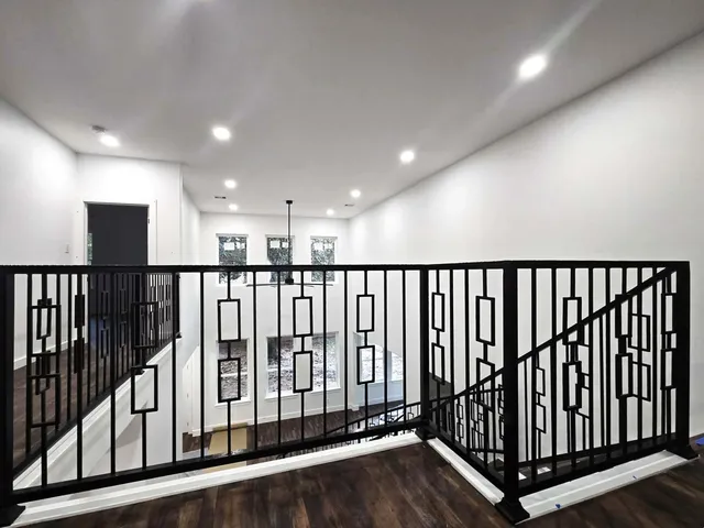 a view of a black gate with wooden floor