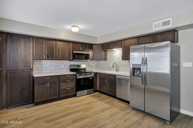a kitchen with granite countertop stainless steel appliances and wooden cabinets