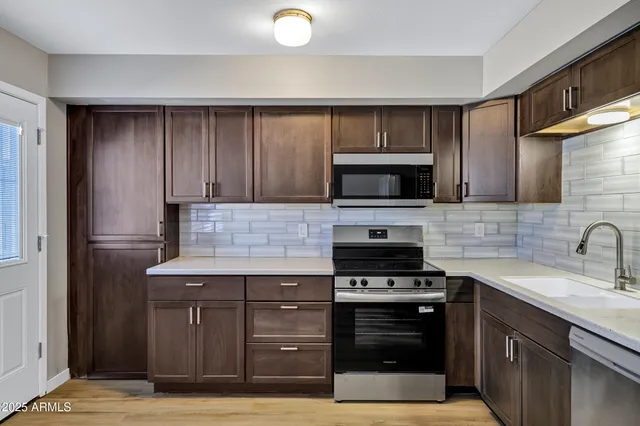 a kitchen with a sink and a stove top oven