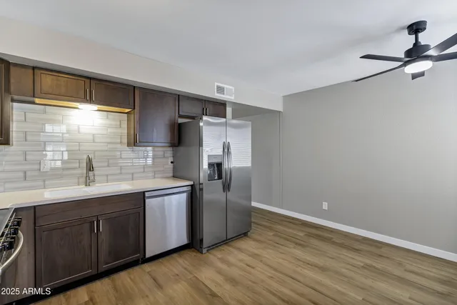 a kitchen with stainless steel appliances granite countertop a sink and refrigerator