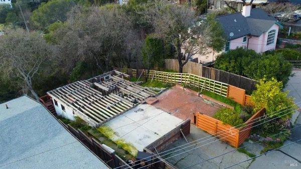 an aerial view of a house with outdoor space and trees all around