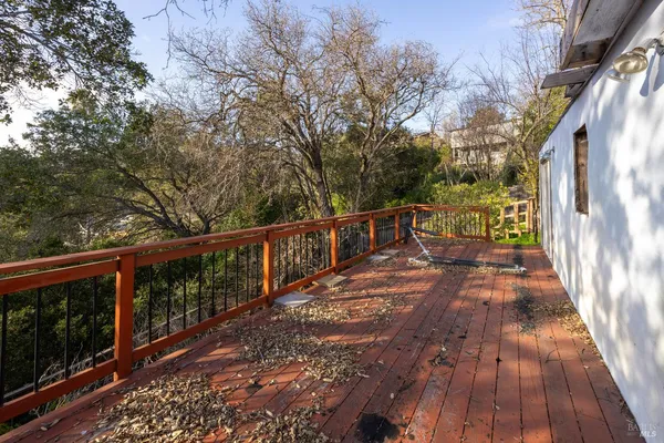 a view of balcony with wooden floor and fence