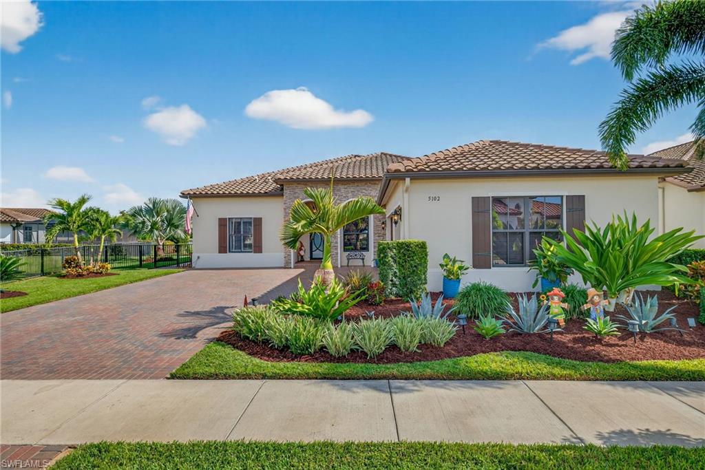 5102 Genoa Street Immokalee, FL 34142 - Photo 2 of 36 a front view of a house with a garden and plants