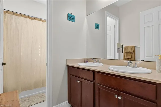 a bathroom with a double vanity sink and a mirror