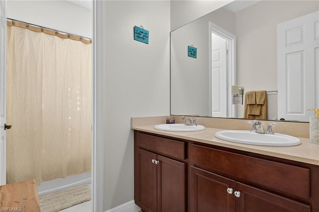 5102 Genoa Street Immokalee, FL 34142 - Photo 21 of 36 a bathroom with a double vanity sink and a mirror