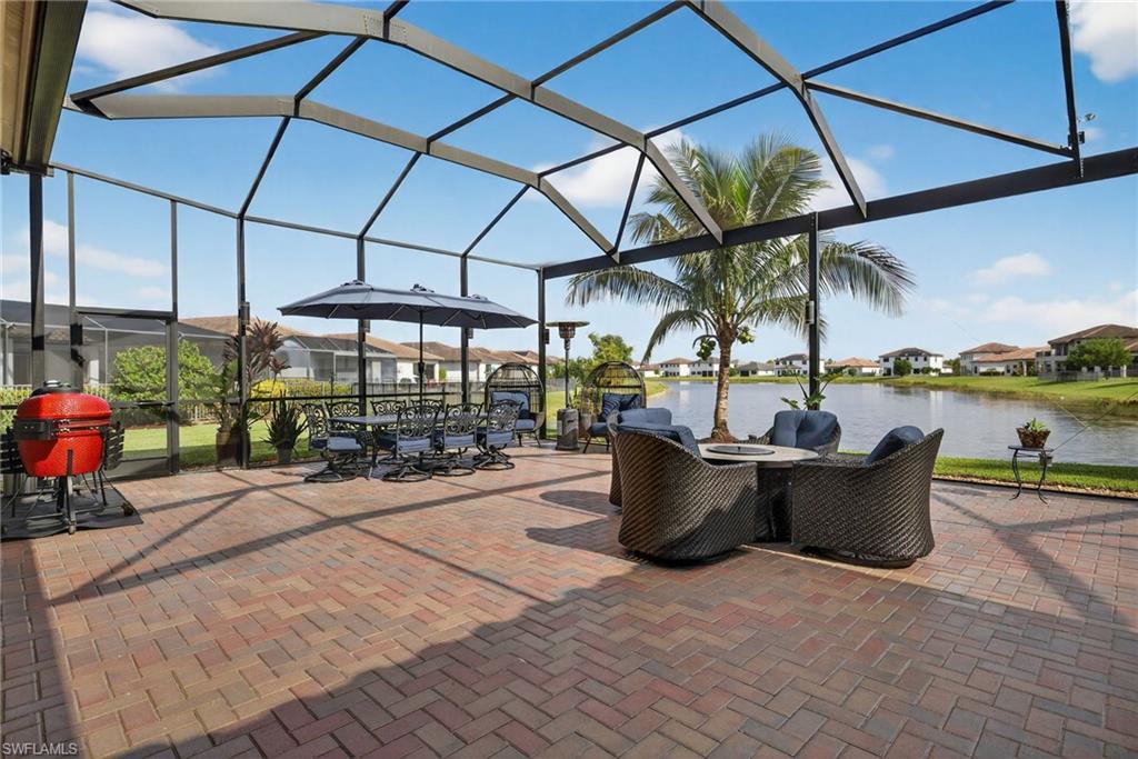 5102 Genoa Street Immokalee, FL 34142 - Photo 28 of 36 a view of a patio with a dining table and chairs under an umbrella