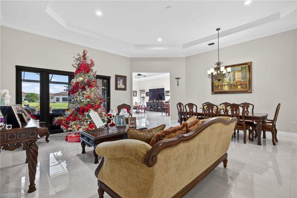 5102 Genoa Street Immokalee, FL 34142 - Photo 3 of 36 a living room with furniture flowers and a chandelier