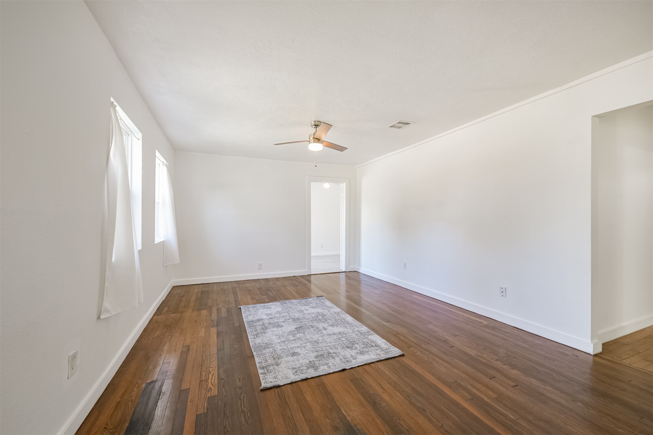 7546 Greendowns Street Houston, TX 77087 - Photo 6 of 33 an empty room with wooden floor and windows