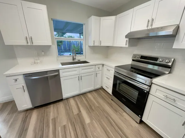 a kitchen with a stove and white cabinets