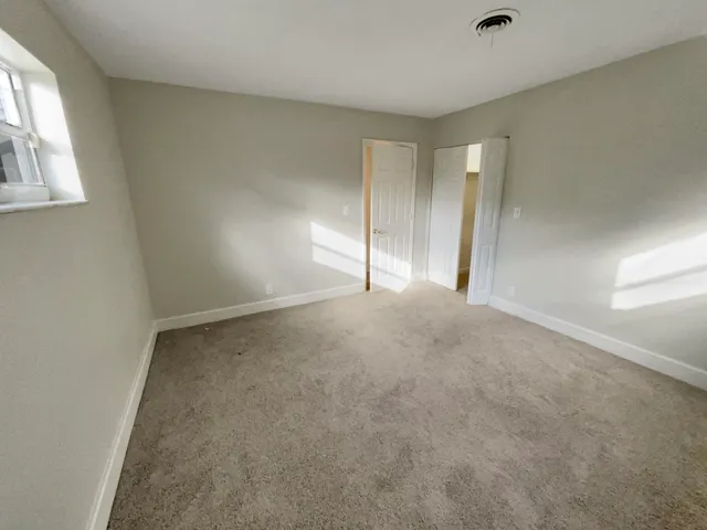 an empty room with windows and closet