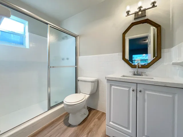 a bathroom with a toilet a sink and mirror