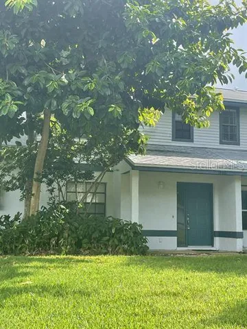 a view of a house with a yard garage and tree