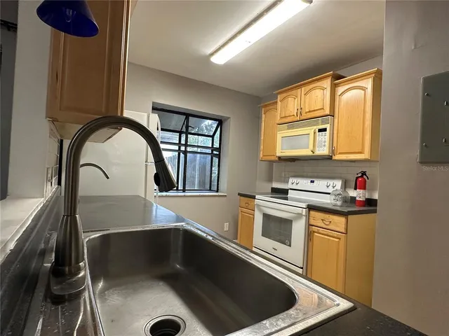 a kitchen with a stove a sink and a microwave