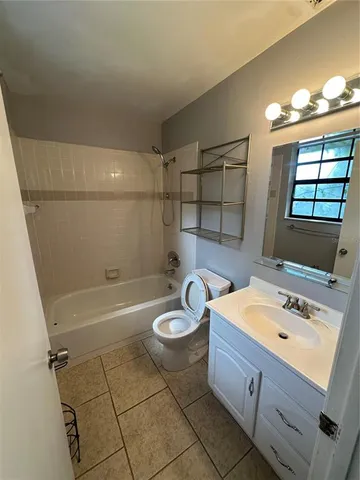 a bathroom with a sink a bathtub and a window