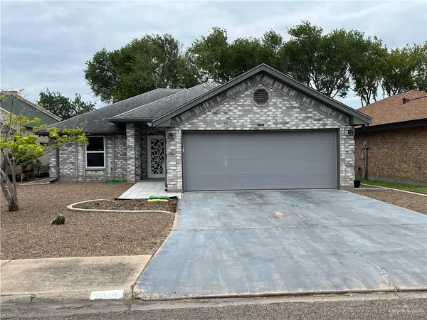 a front view of house with garage and trees around