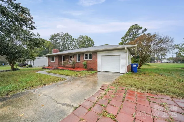 a view of a yard in front of a house with large tree