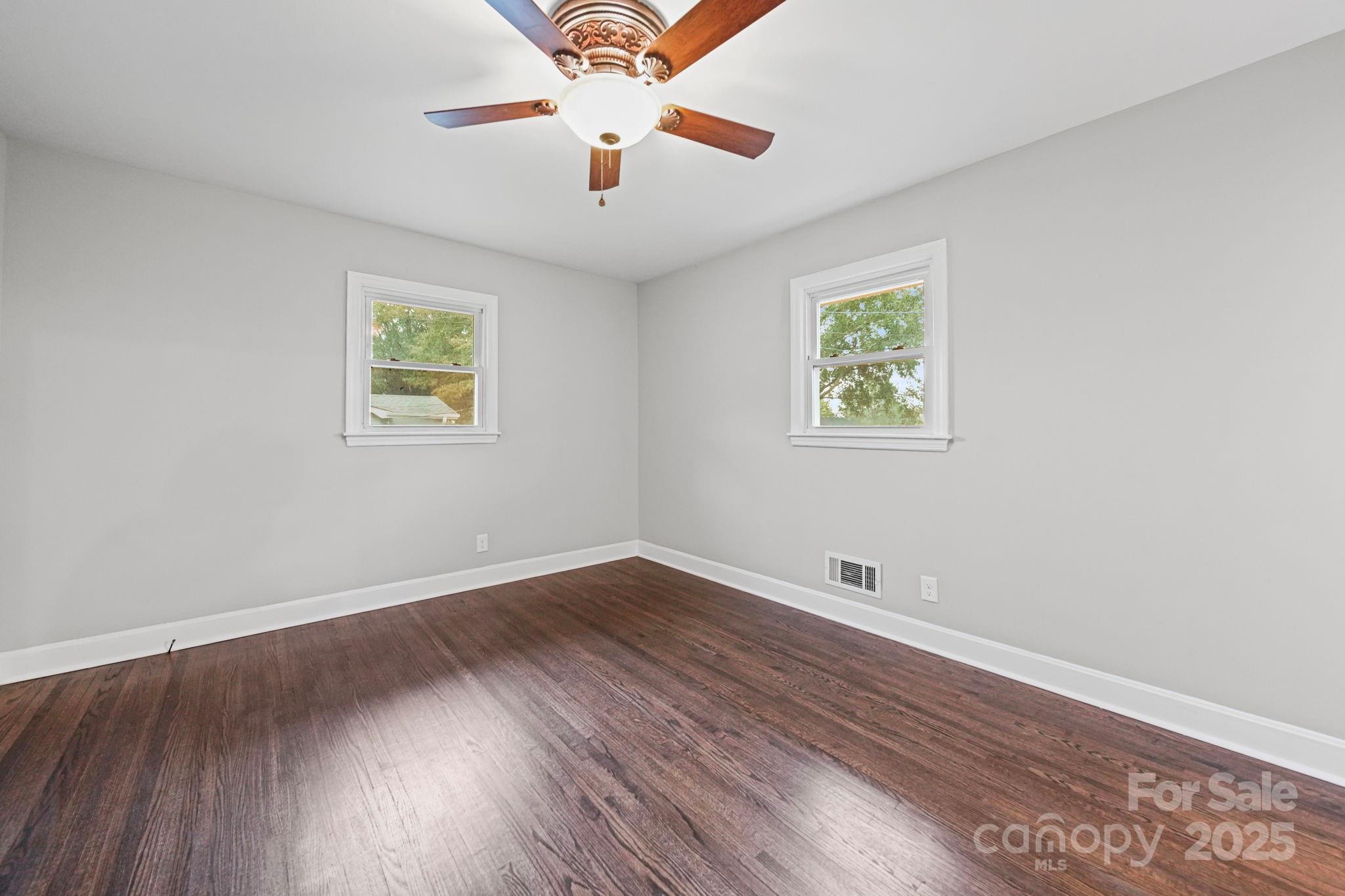 1331 Stegall Road Marshville, NC 28103 - Photo 16 of 35 an empty room with wooden floor ceiling fan and windows