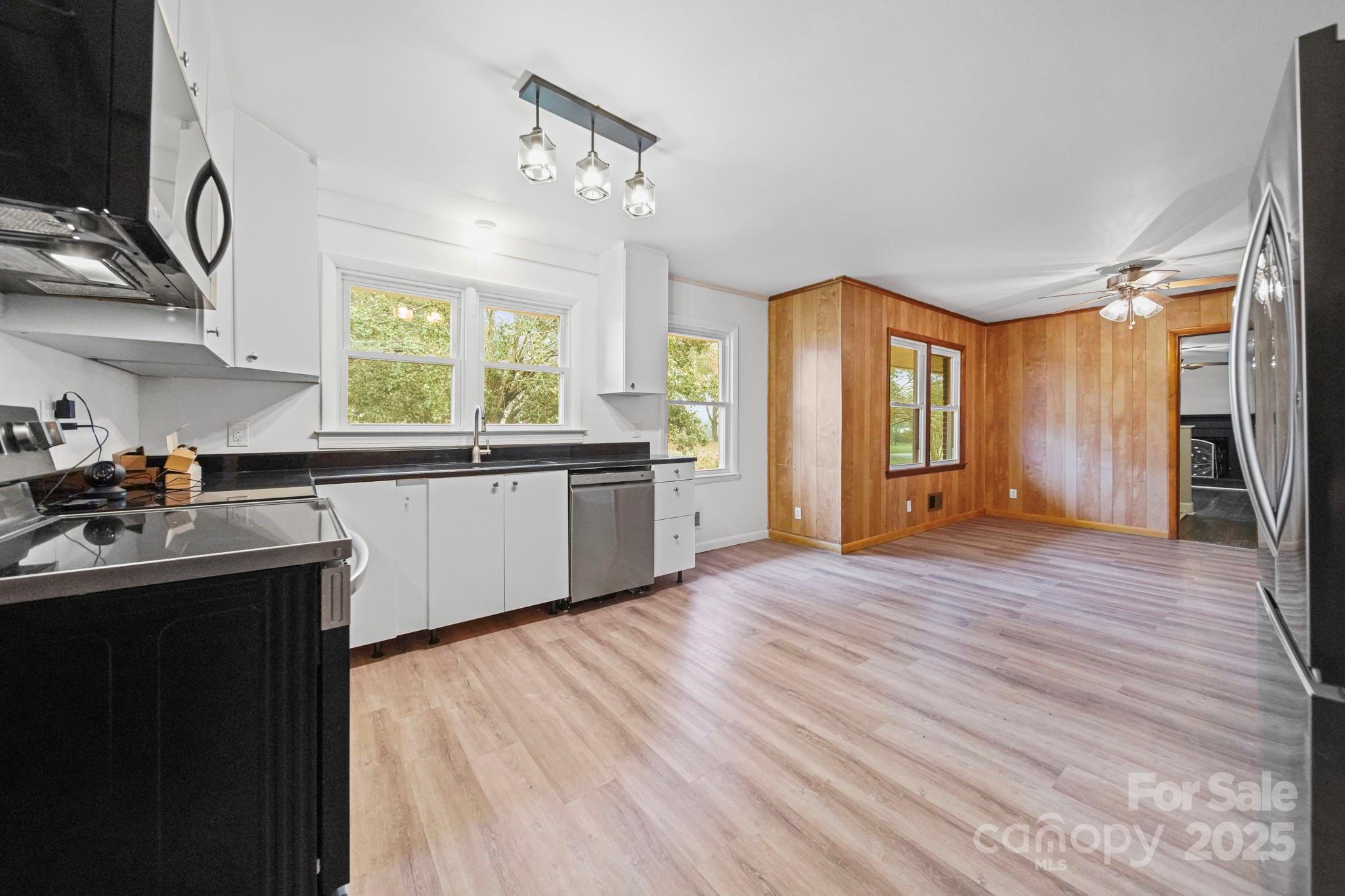 1331 Stegall Road Marshville, NC 28103 - Photo 9 of 35 a kitchen with stainless steel appliances granite countertop a sink cabinets and wooden floor