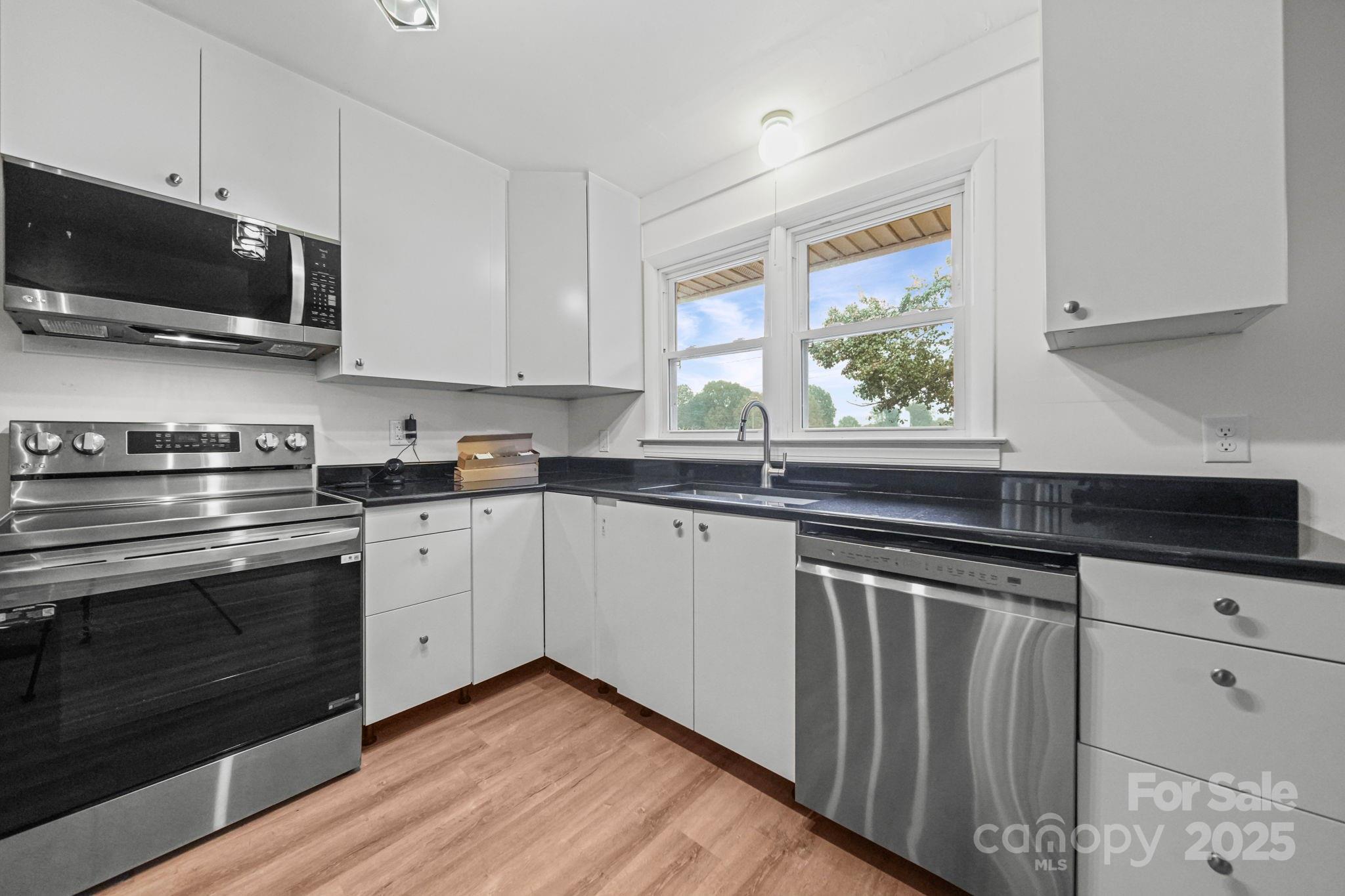 1331 Stegall Road Marshville, NC 28103 - Photo 10 of 35 a kitchen with granite countertop a sink cabinets stainless steel appliances and a window