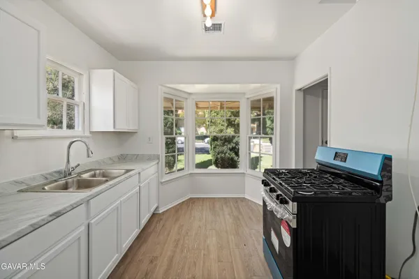 a kitchen with a sink stove top oven and cabinets