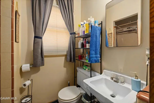 a bathroom with a sink a toilet and mirror