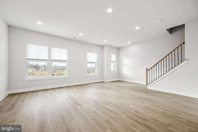 a view of a kitchen with kitchen island stainless steel appliances wooden floor and living room view