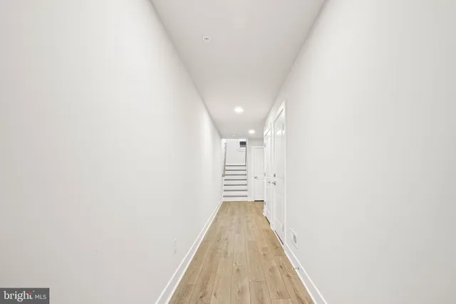 a view of a hallway with wooden floor