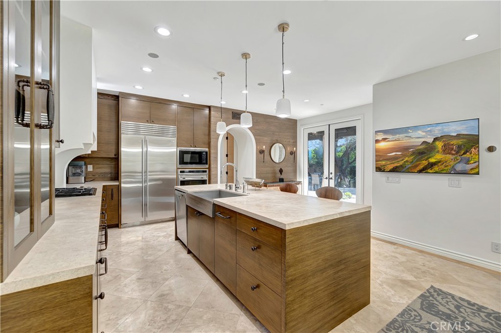 16 Eucalyptus Newport Coast, CA 92657 - Photo 17 of 38 a large kitchen with stainless steel appliances a large counter top a stove a chimney a sink and a refrigerator