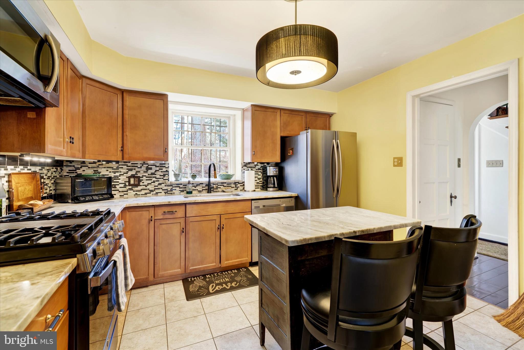 1711 Alsace Road Reading, PA 19604 - Photo 15 of 45 a kitchen with stainless steel appliances granite countertop a stove a refrigerator a sink a dining table and chairs with wooden floor