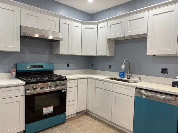 a kitchen with cabinets appliances a sink and a counter top