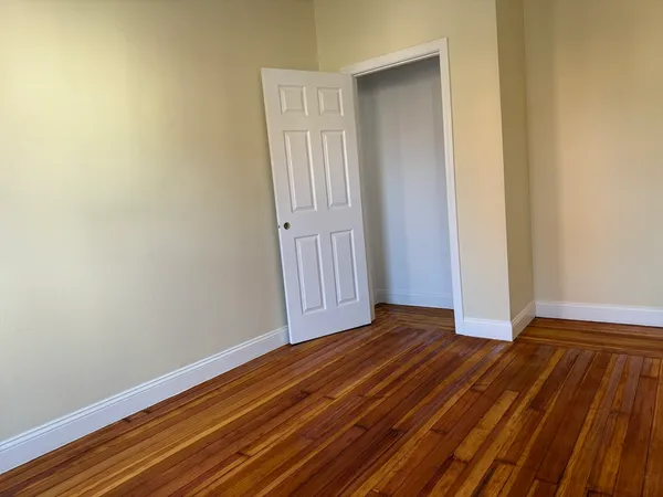a view of a room with wooden floor and white walls
