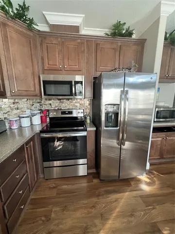 a kitchen with kitchen island granite countertop a stove and a refrigerator