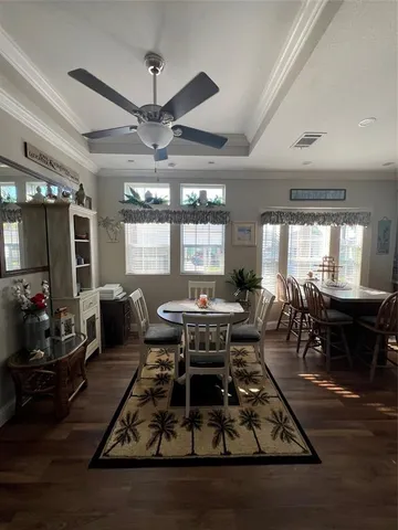 a living room filled with furniture a dining table and a chandelier
