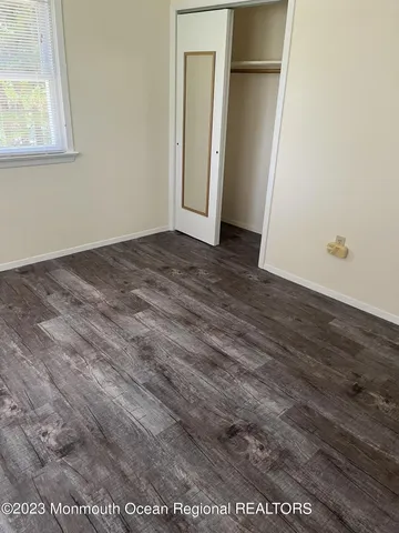 an empty room with wooden floor and closet
